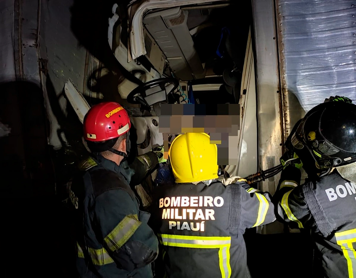 Bombeiros auxiliam na retirada do corpo que ficou preso às ferragens do caminhão.