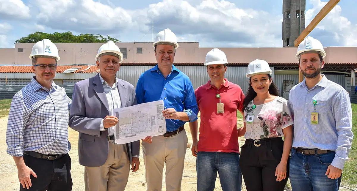 No centro da foto o Reitor Gildásio Guedes e o Superintendente Paulo Márcio seguram a planta impressa da obra
