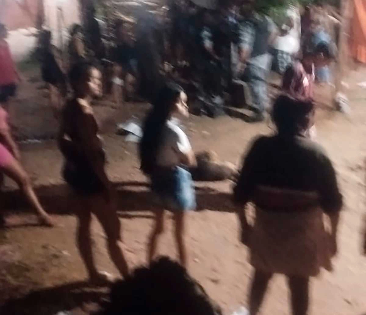 Pessoas se aglomeram em torno do corpo da vítima após o crime