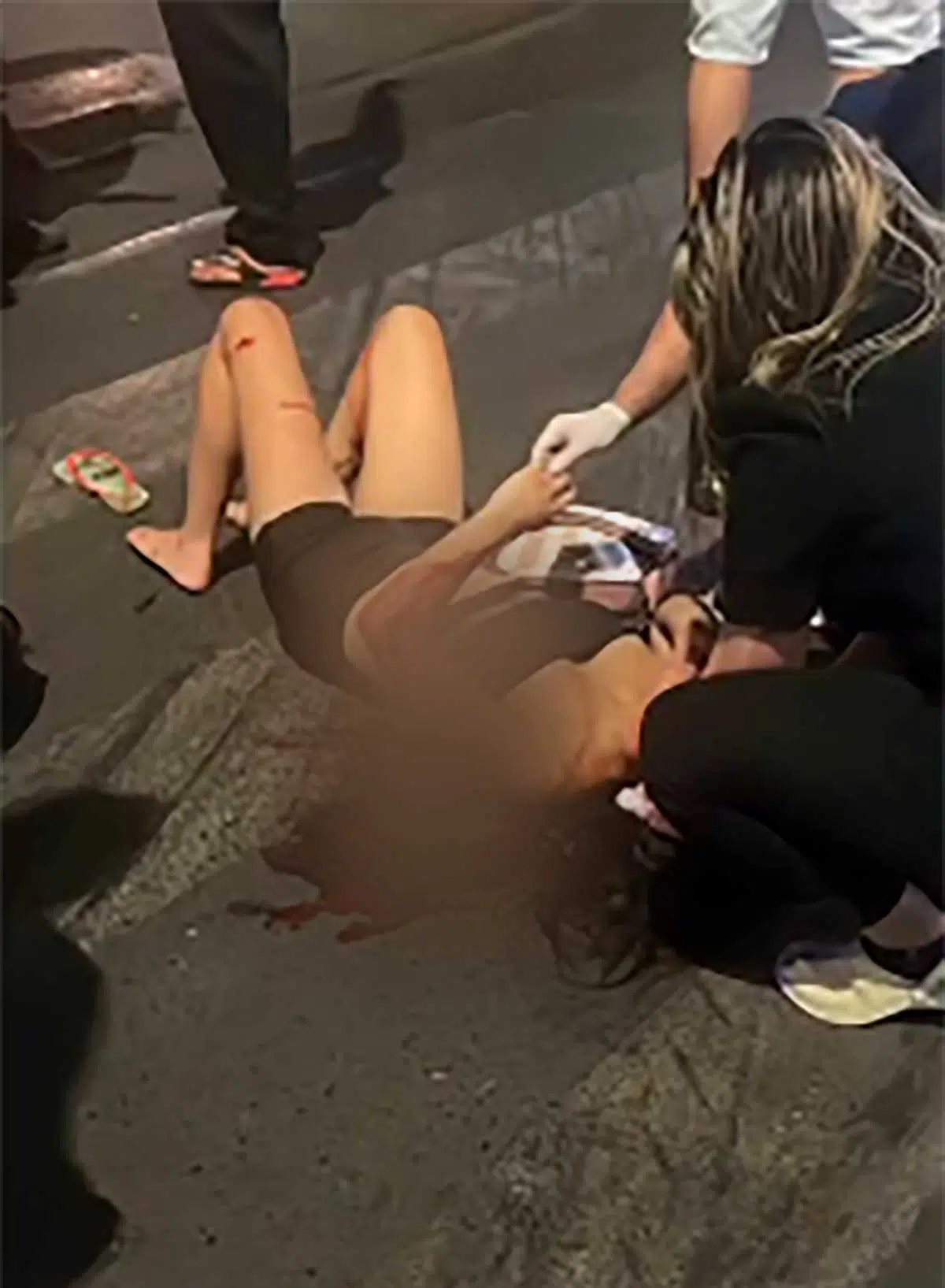 vítima sendo socorrida por uma popular que passava pelo local no momento do acidente
